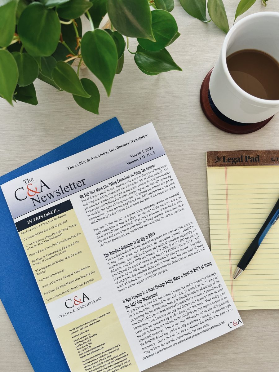 A flat lay photo of the Collier & Associates Newsletter on top of a blue folder, next to a coffee cup, yellow legal pad, and philodendron plant.